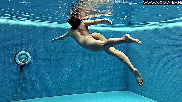 Babe goes for a naked swim in a big pool