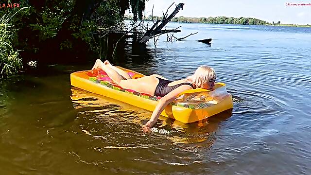 Floating and relaxing on a large and rare transparent inflatable mattress on the river